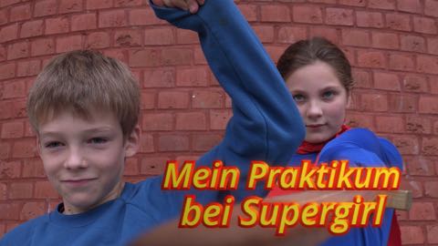 Farbiges Titelbild der Mysterykomödie "Mein Praktikum bei Supergirl" mit den beiden Hauptdarstellern vor einer roten Mauer.